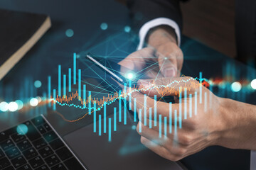 Businessman trading stocks using on-line app on phone. Financial graph hologram.