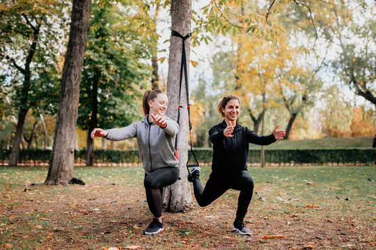 Women Training With Trx Outside In The Park.