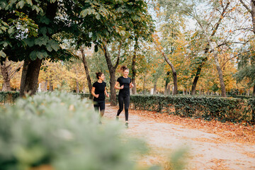 Fototapeta premium A couple of women running outside trought the park