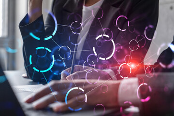 Two businesswomen working together in office. Abstract tech icons holographic illustration double exposure.