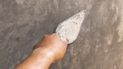 Tiler's hand.bricklayer plaster a wall inside a building
