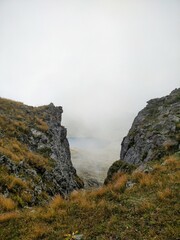 cliff cliff into fog overlooking blue lake