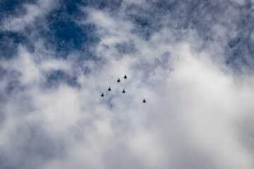bright blue sky with jet fighter formation flying