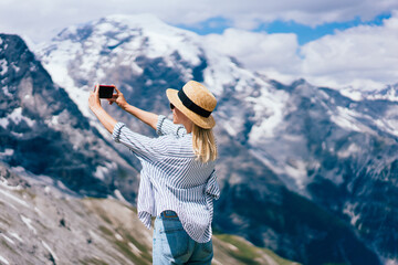 Fototapeta na wymiar Female traveler shooting mountains on cloudy day