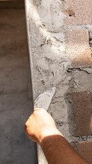 Tiler's hand.bricklayer plaster a wall inside a building