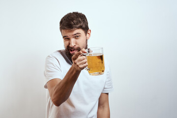 Fototapeta premium man with a mug of beer in his hands and a white t-shirt light background mustache beard emotions model