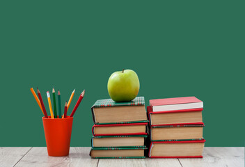 Books textbook in colorful covers on a green background. Back to school distance home education.Quarantine concept of stay home.