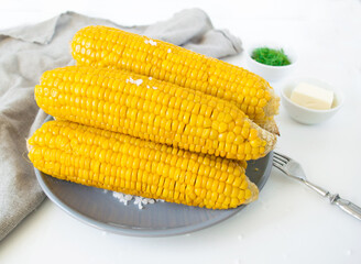 grilled corn, boiled corn on a wooden white plate. Vegetarian food, healthy food.