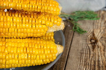 grilled corn, boiled corn on a wooden white plate. Vegetarian food, healthy food.
