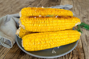 grilled corn, boiled corn on a wooden white plate. Vegetarian food, healthy food.