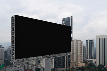 Naklejka premium Blank black road billboard with Kuala Lumpur cityscape background at day time. Street advertising poster, mock up, 3D rendering. Side view. The concept of marketing communication.