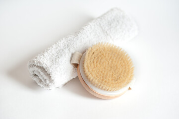 massage brush and white towel on white background