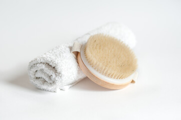 Fototapeta na wymiar massage brush and white towel on white background