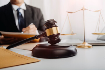 Justice and law concept.Male judge in a courtroom with the gavel, working with, computer and...