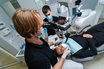The dentist examines the patient's teeth with a dental microscope. Modern medical equipment. Oral treatment concept. Closeup. Selective focus.