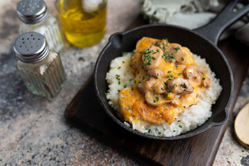 Chicken Lombardy made with five cheese and mushrooms over white rice 