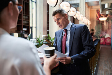 Waist up portrait of advisor and his assistant during coffee break