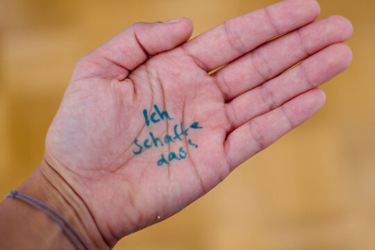 Ein Mensch, der sich "Ich schaffe das!" als Motivation und f&uuml;r mehr Selbstvertrauen auf die Hand geschrieben hat.