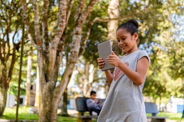 girl walking in a park with a tablet