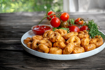 handmade tarallini with tomatoes and herbs called taralli or TARALLINI in Italian bakeries in southern Italy on a wooden background