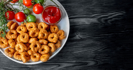 handmade tortellini with tomatoes and herbs is called taralli or TARALLINI in Italian bakeries in southern Italy on a wooden background. Top view, copy space