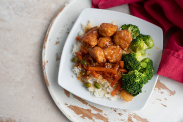 Orange chicken stir fry served with broccoli and rice