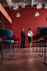 Businessman and businesswoman standing near dashbord during presentation