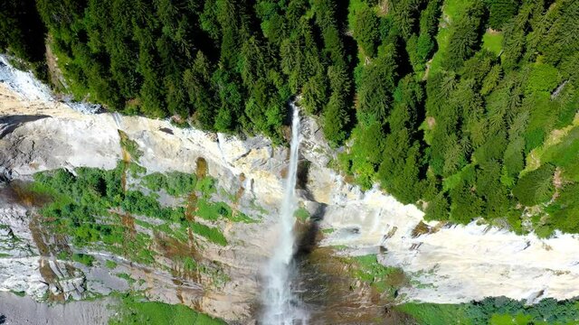 Aerial view of Staubbach Falls in Swiss. A waterfall surrounded by the green forest of the Alps - 4K in drone view