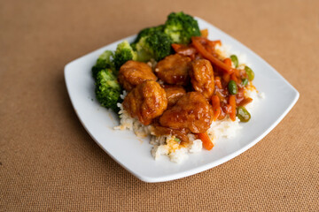 Orange chicken stir fry served with broccoli and rice