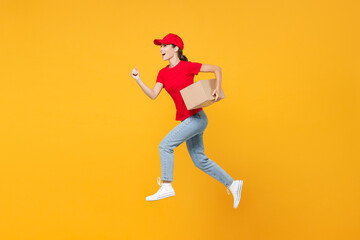 Fototapeta na wymiar Full length body jumping delivery employee woman in red cap blank t-shirt uniform work courier in service during quarantine coronavirus covid-19 virus hold cardboard box isolated on yellow background.