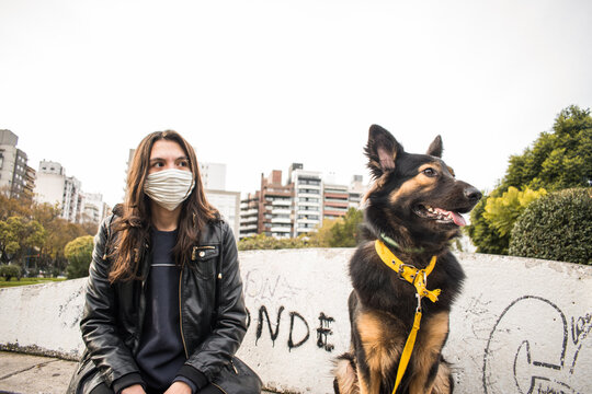 Young Beautiful Girl With Adorable Dog In The Park, With Mouth Cover, Quarantine Concept, Covid 19, New Normal, Social Distance