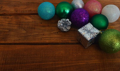 New Year's layout on a wooden background. Christmas decorations for the tree, balls, gifts.