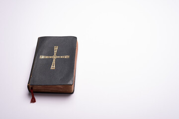 Obraz premium Old Holy Bible on plain white background desk with copy space for timetable, wedding info, communion schedule, masses, catechism classes or catechesis