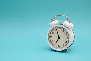 White alarm clock photography on blue background