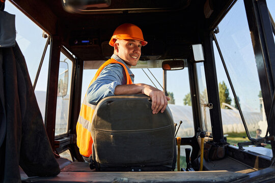 Driver in hardhat siiting in tracktor