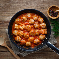 Meatballs in a pan in sweet and sour tomato sauce. Top view.