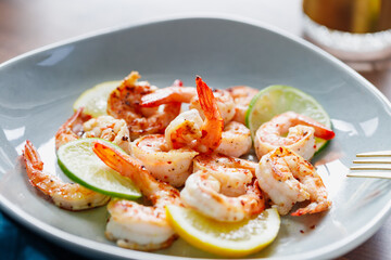 Fototapeta na wymiar Fried tiger shrimp with lime, lemon and spices on a ceramic dish. Healthy dinner or lunch concept.