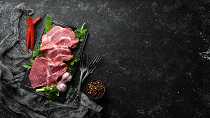 Raw veal meat with parsley and spices on the table. Beef steak. Top view. Free space for your text. Rustic style.