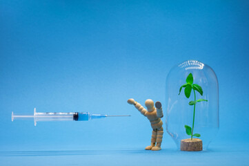 A person protects his immune system in the form of a green sprout in a flask from a vaccine with a...