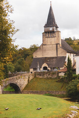 Landmark of medieval town in France. Ancient village on the river bank. Church with bridge over river in the mountains. Medieval heritage. Old architecture. Beautiful ancient village in Europe. 