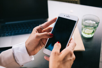 Cropped image of woman's hands holding modern smartphone connected to 4G internet browse web page, female typing text messages and communicating in share social networks on mobile phone