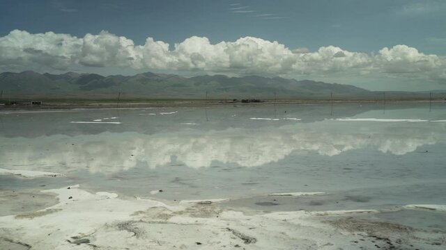 Chaka Salt Lake with Clouds and Sky Reflected in Water - Slow Pan Across - Qinghai Xining Ulan County China