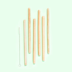 Reusable bamboo straws with brush on the mint background. No plastic straws concept. Zero waste lifestyle. 