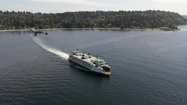 Drone / aerial footage of the Vashon ferry and the ferry terminal with cars loading and unloading in Fountleroy, near Lincoln Park and Seattle, Washington