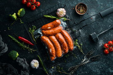 Smoked sausages in vacuum packaging. Top view. On a black background.