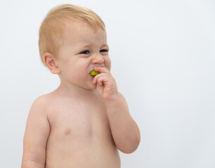 Baby boy trying and tasting new food. Dieting, vegetarian and healthy nutrition concept.