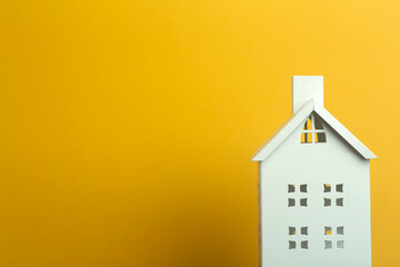 Toy house on yellow background. Real estate, rental housing and house concept.