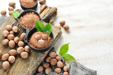 Ground nutmeg in bowls on a white background. Indian spices. - obrazy, fototapety, plakaty