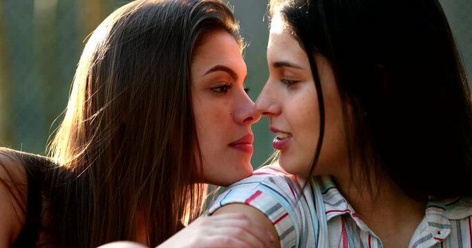 Lesbian girlfriends candid kiss. intimate moment together