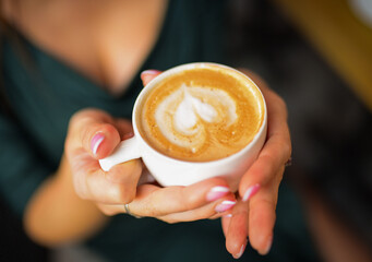 cap of coffee,cappuccino,latte in women hands close up